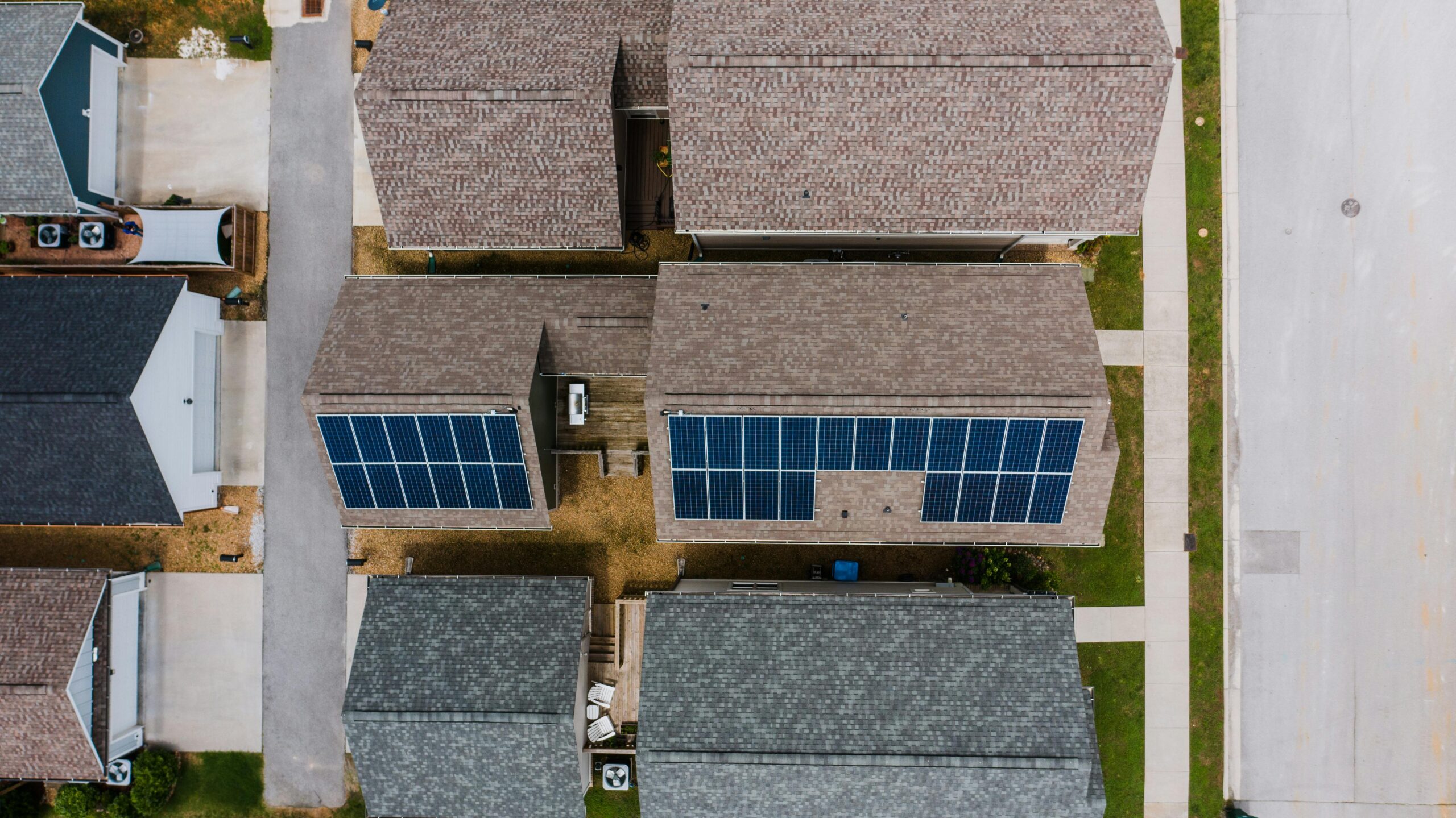 add-ons, such as solar panels, may not be on the initial estimate for roof replacement, so the middle roof may cost more than the brown or gray one next to it.