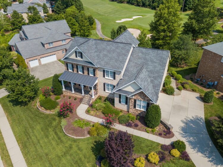 A stone house with asphalt shingles, one of the many materials needed for roofing a house.