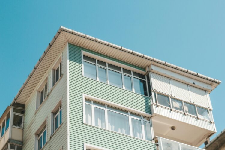 A green and white building with white house soffit and fascia.