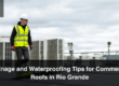 A roofer inspecting the drainage and waterproofing on a commercial roof